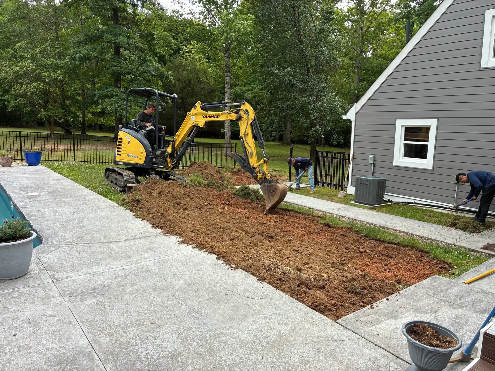 Removing soil beside the poolside walkway