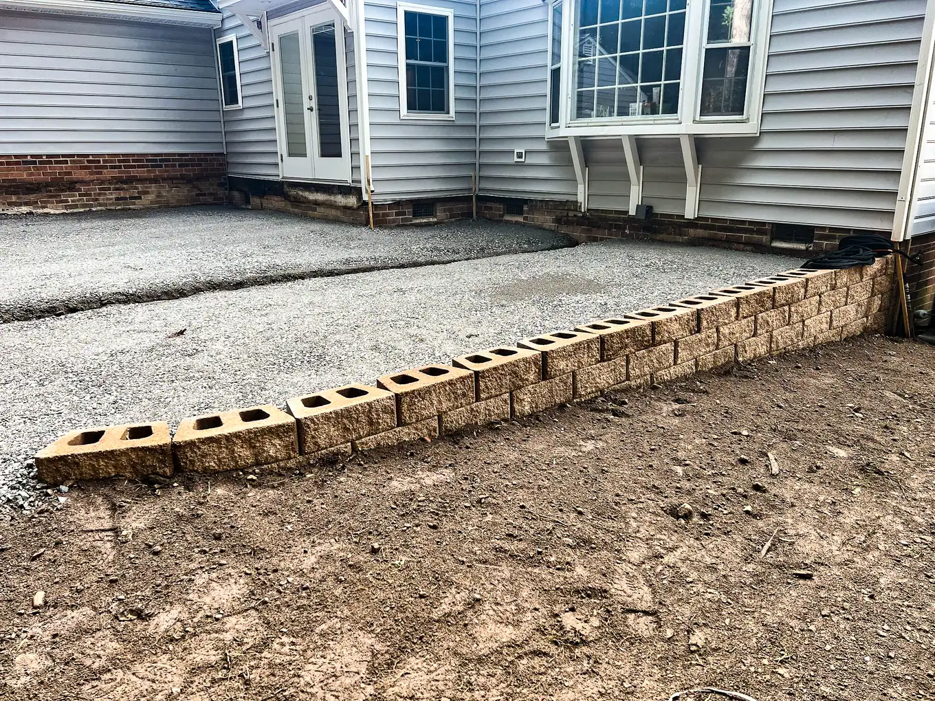 Retaining wall blocks installed along the prepared patio base