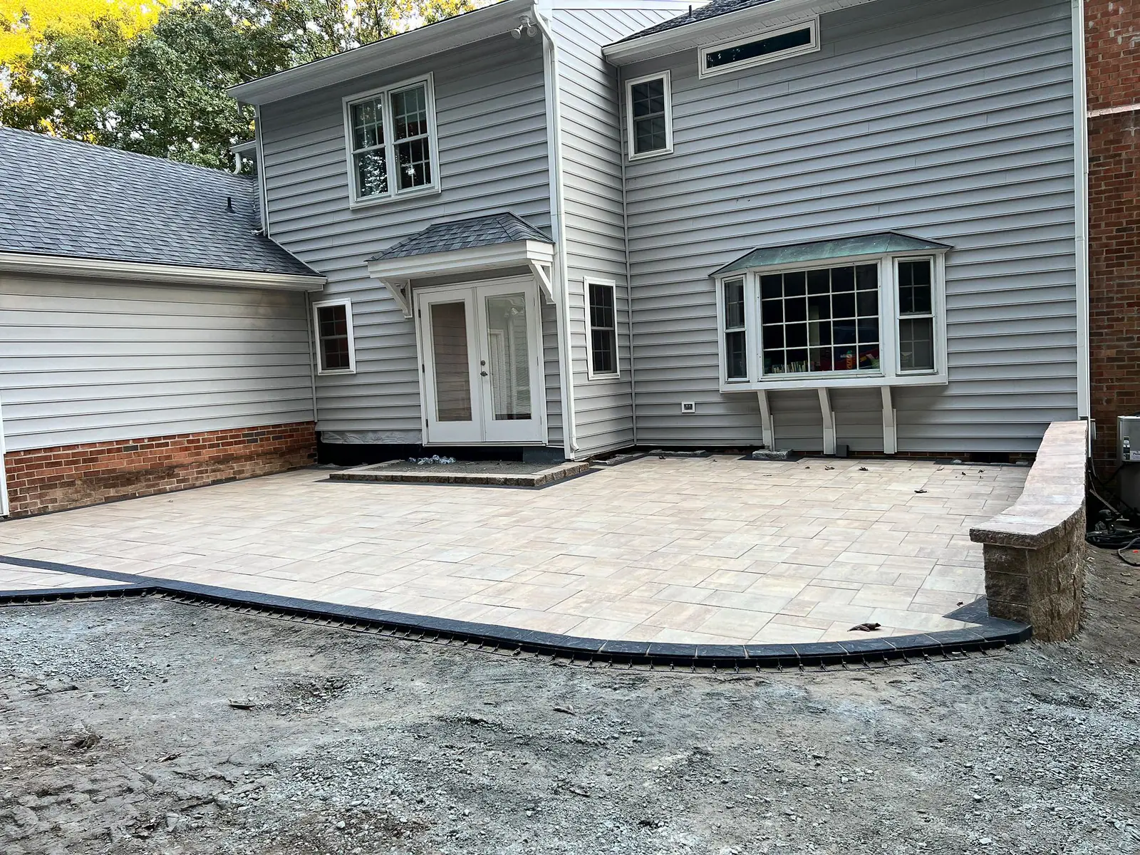 Finished paver patio bordered by the retaining wall