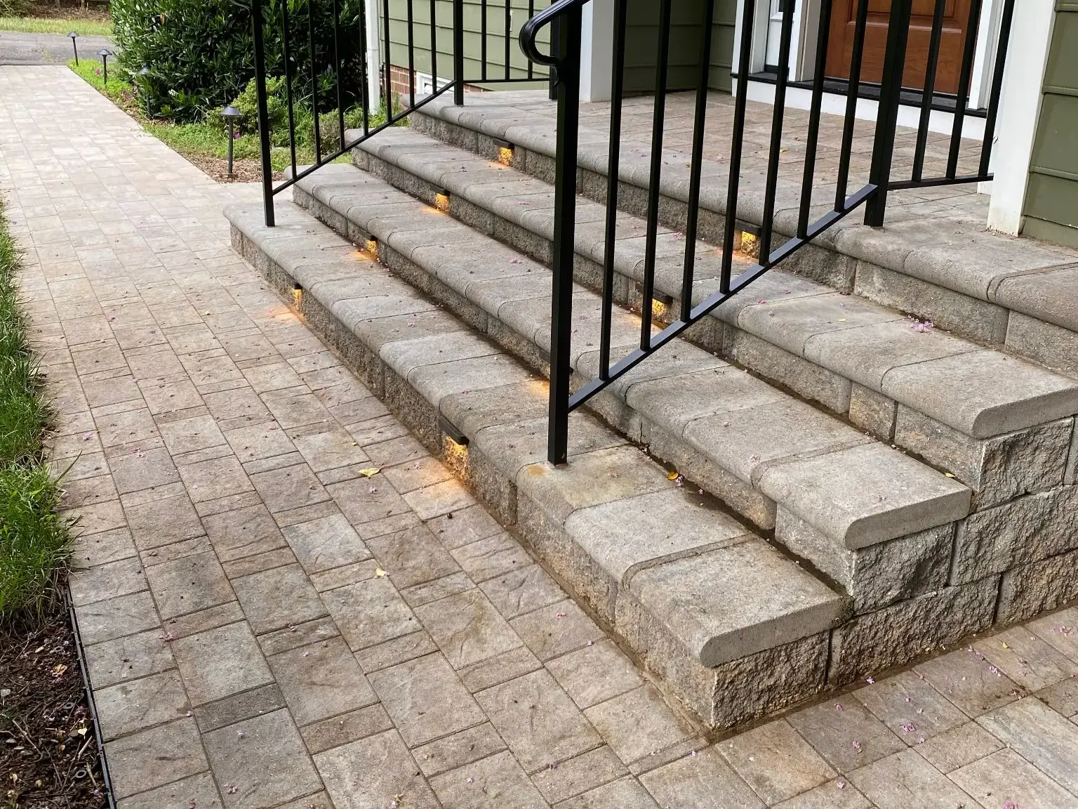 Stone entrance steps with a black railing