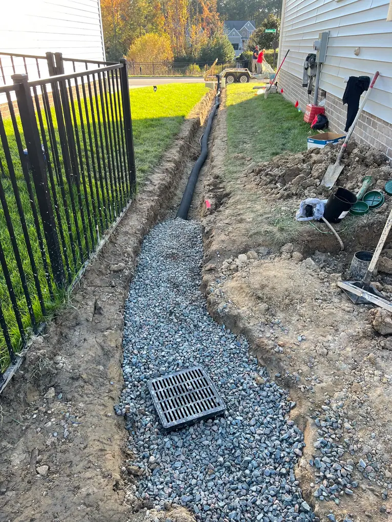 French drain trench and drainage stone beside the house
