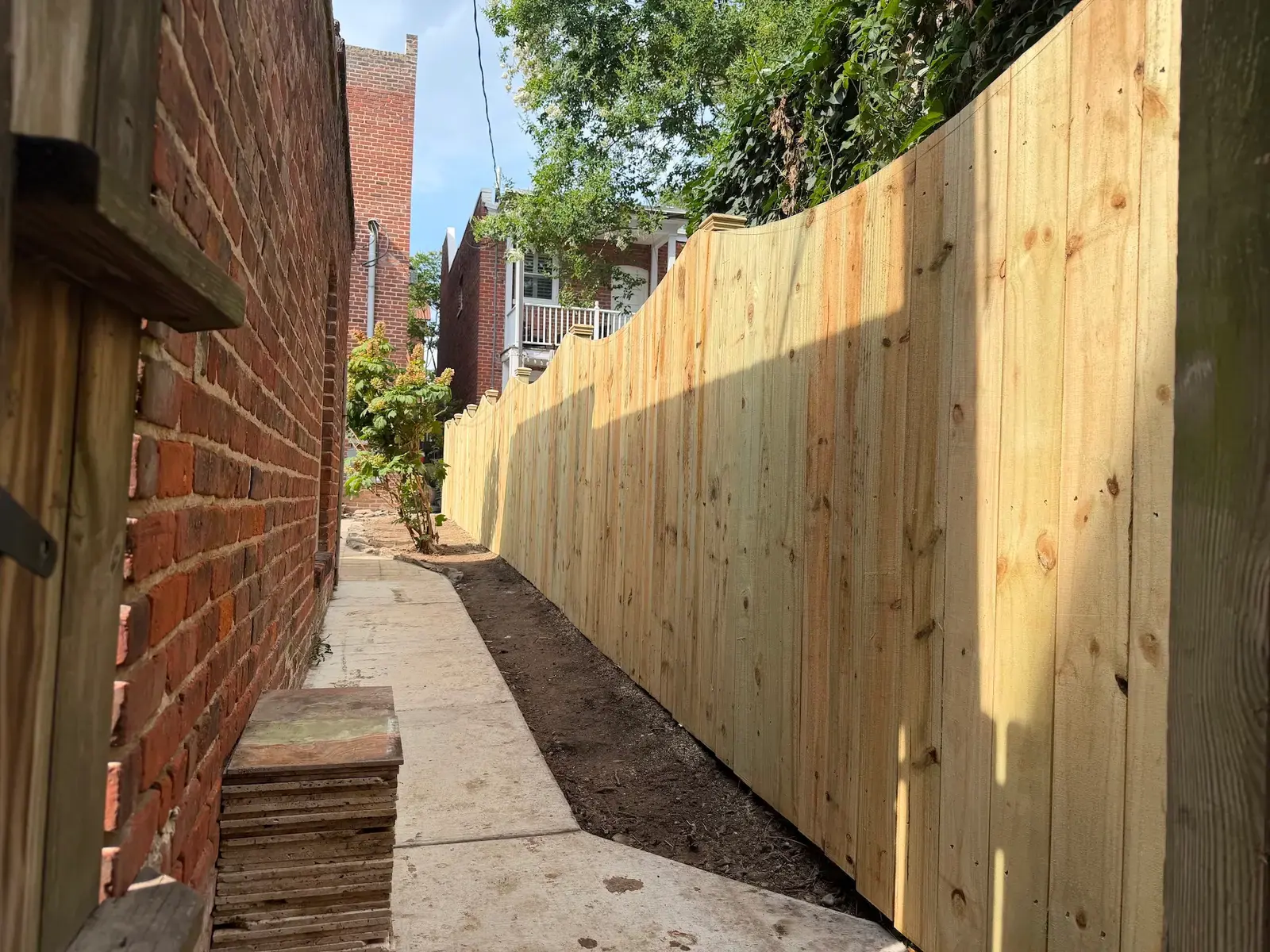 Side passage alongside the new wooden fence