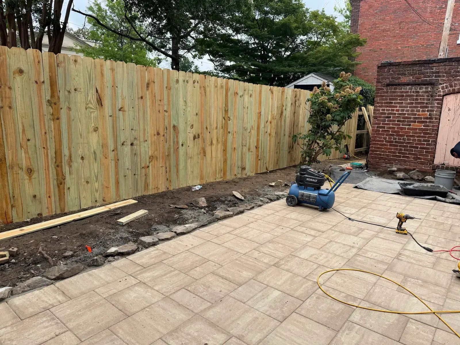 New fence bordering the patio during finishing work