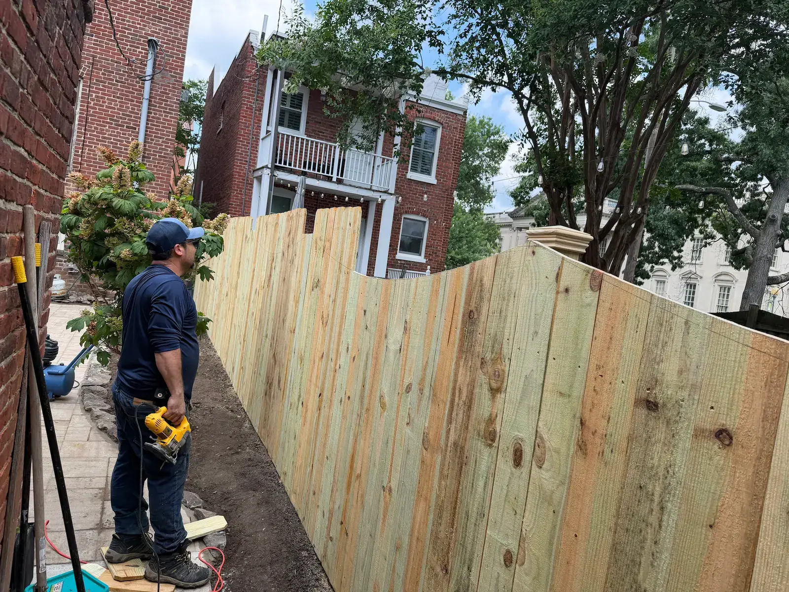 Wooden privacy fence installation beside the patio