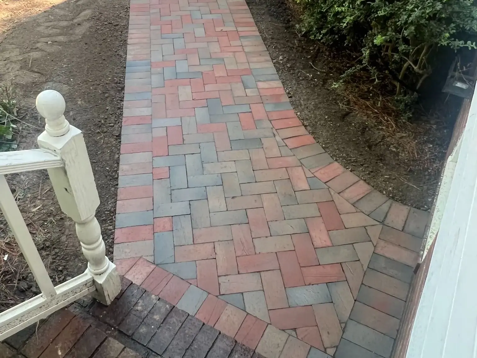 Multicolor paver walkway beside the home