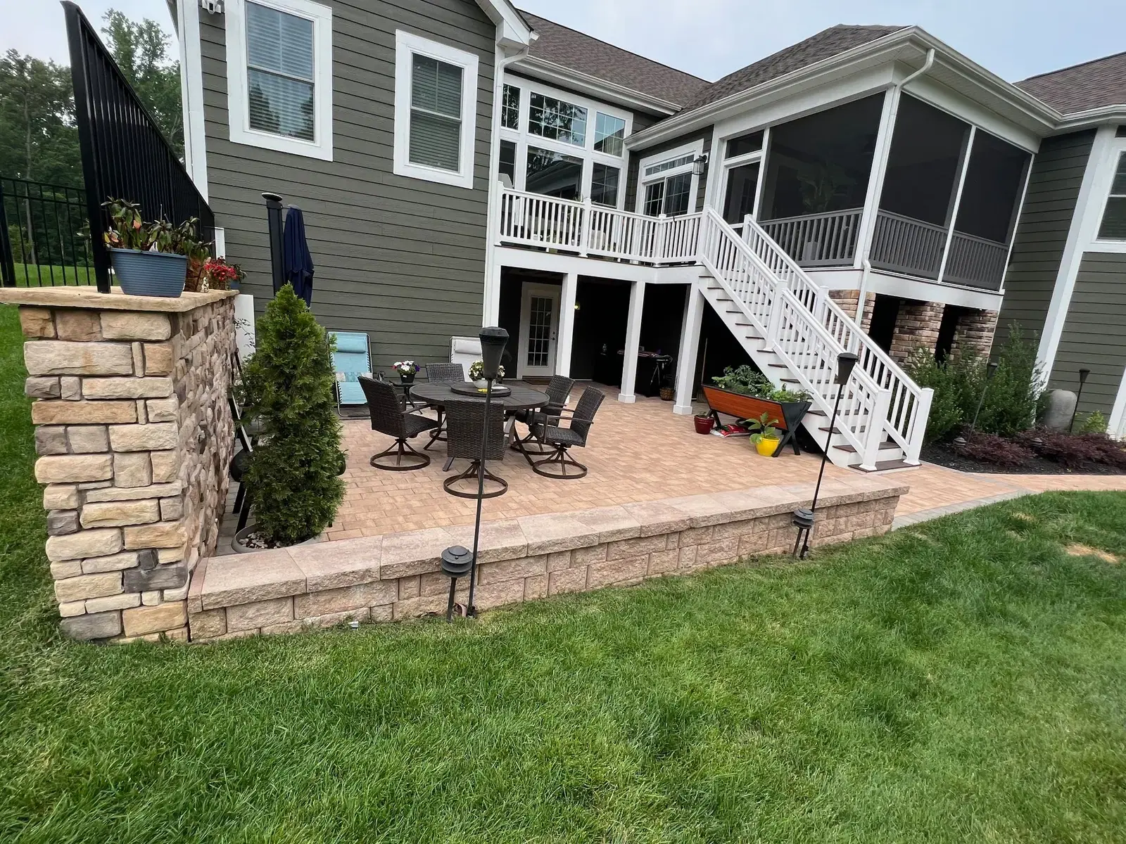 Paver patio below a screened porch