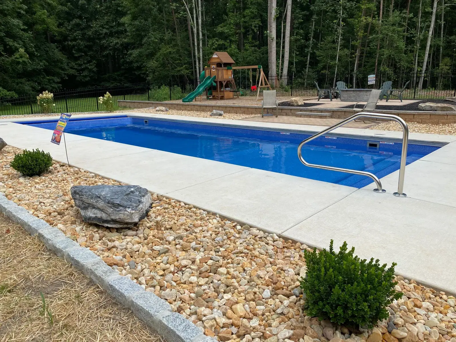 River rock, shrubs and boulders along the pool
