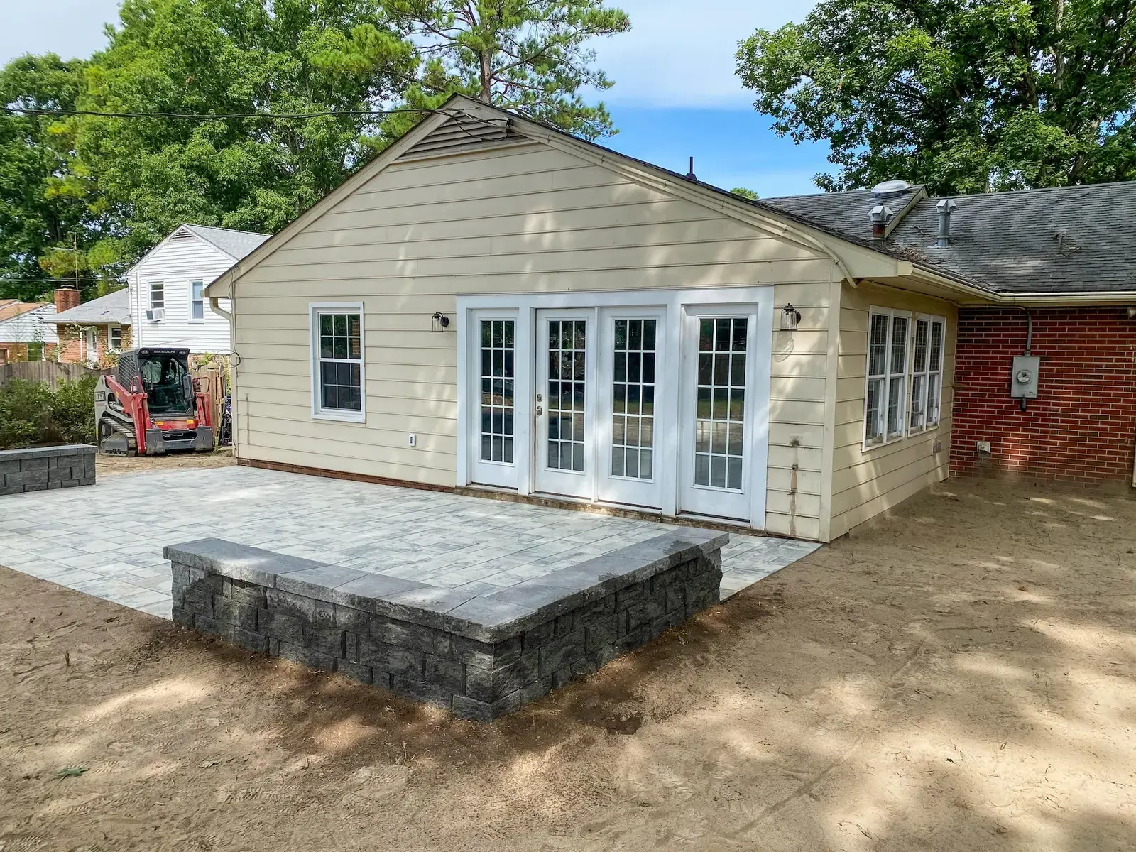 New patio and low block walls beside the rear entrance