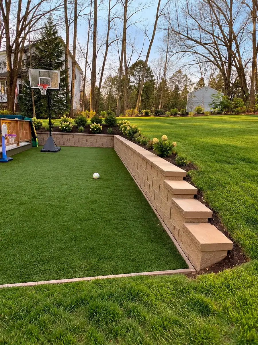 AI visualization of a backyard with artificial lawn bordered by a capped retaining wall