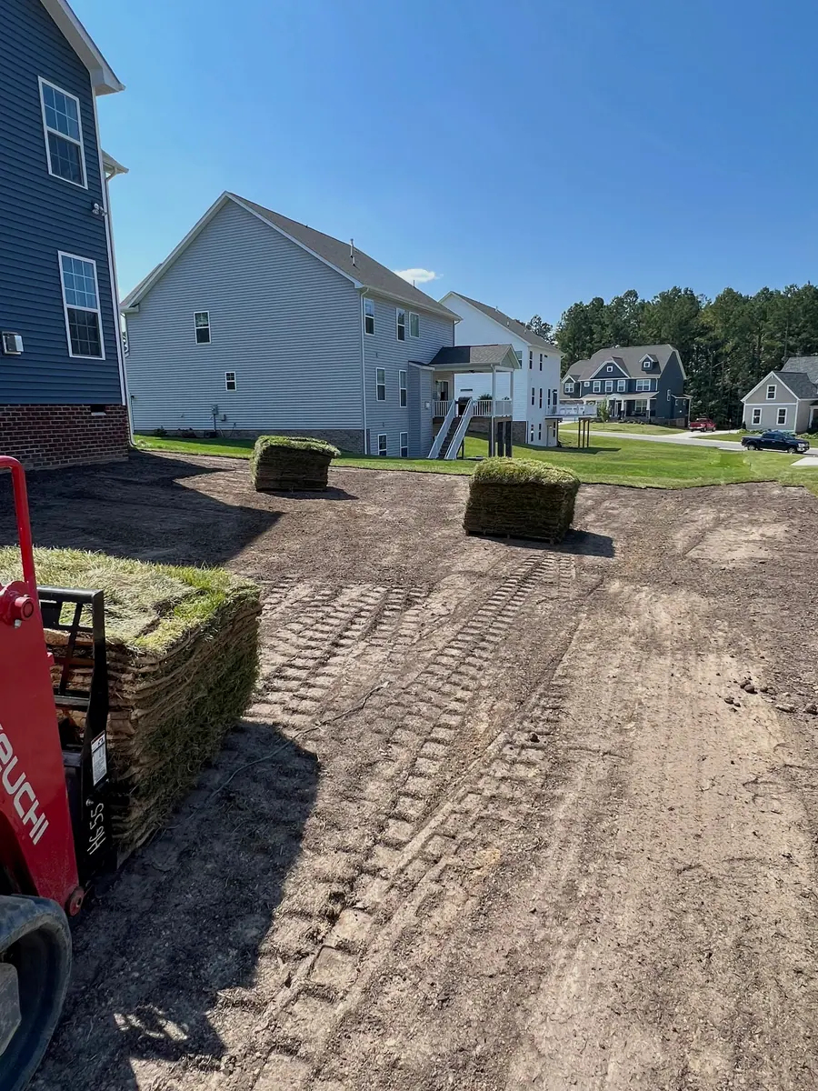 Prepared soil beside the newly sodded lawn