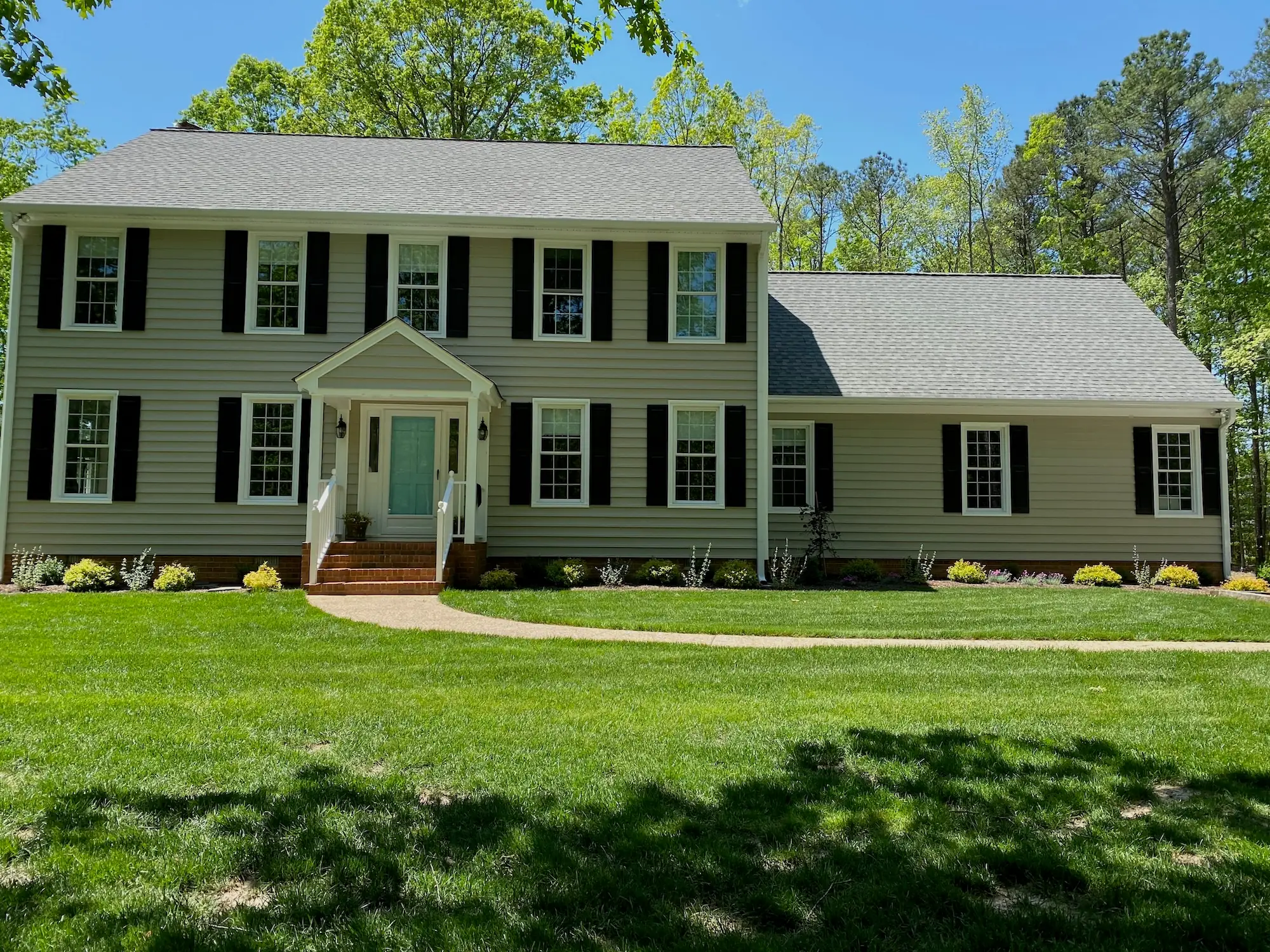 The same Hames property after work, with an established lawn and planted beds